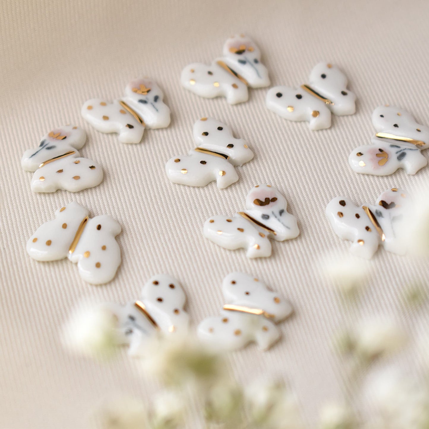 Butterfly earrings detail – delicate butterfly motif with 24k gold ceramic decoration, by Joska Handmade