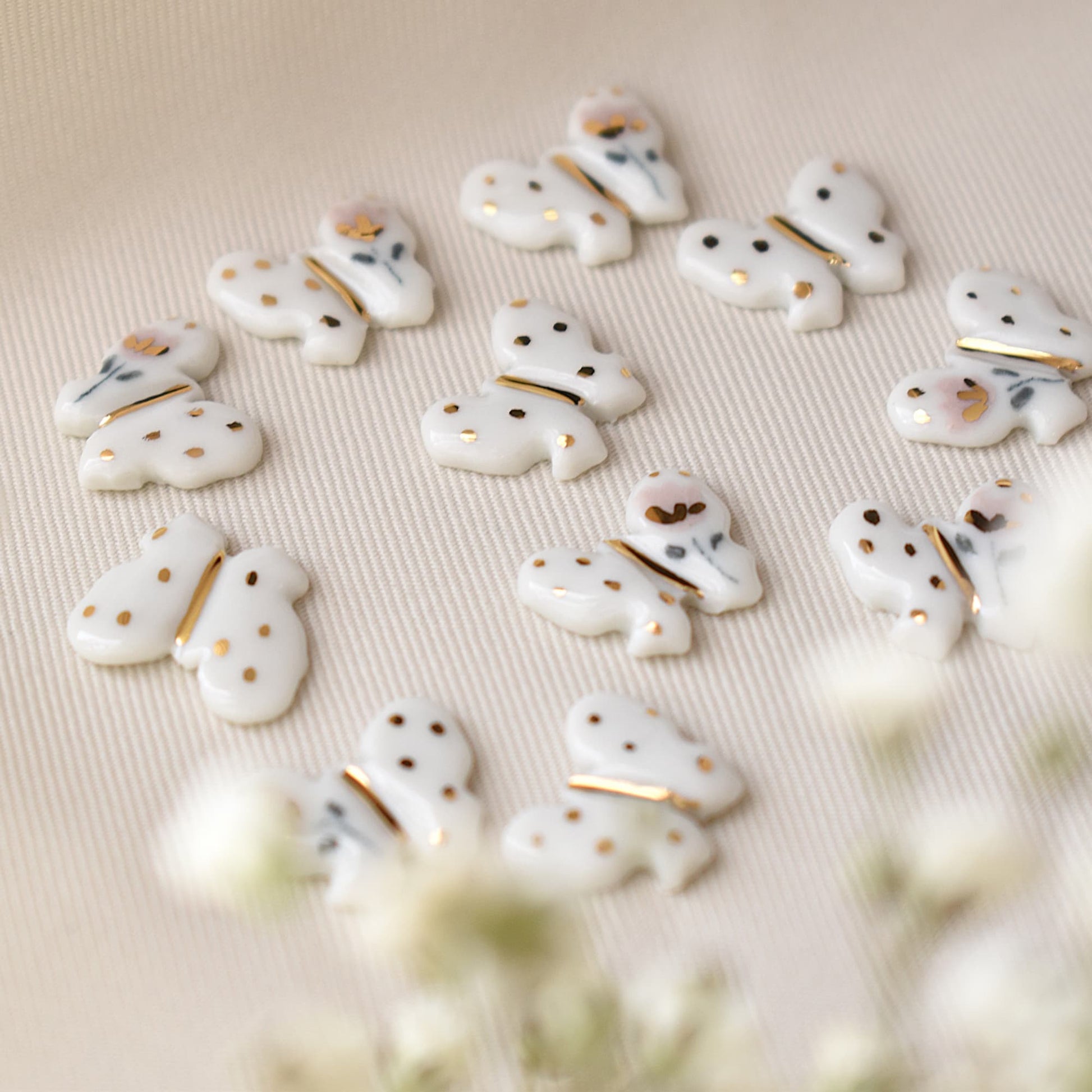 Butterfly earrings detail – delicate butterfly motif with 24k gold ceramic decoration, by Joska Handmade